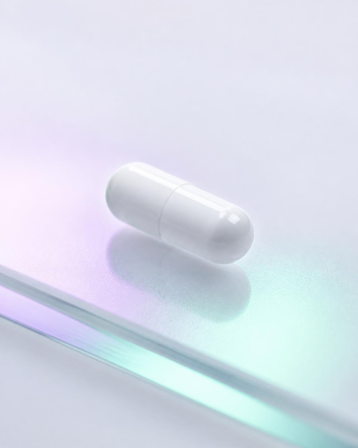 Einzelne weiße Reta3 Kapsel auf mattierter Glasfläche mit schillerndem Lichtreflex